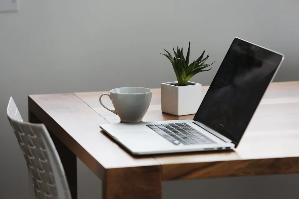Home office desk with a laptop by a window